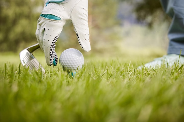 Mano a mano colocando una pelota de golf en el tee