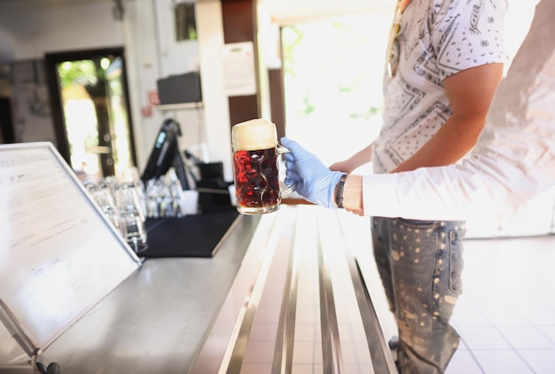 Mano a mano frente a un vaso frío con kvas o cerveza