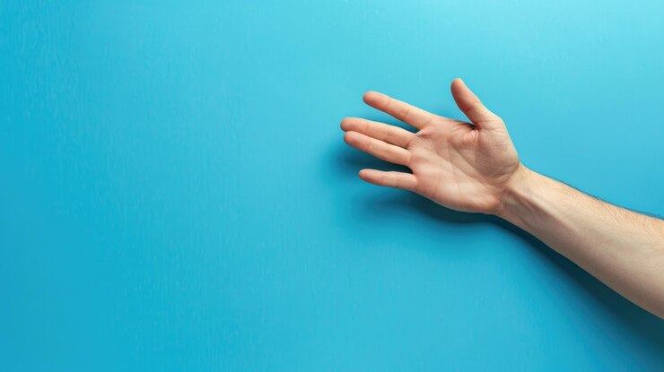 Foto mano masculina blanca extendida contra un fondo azul haciendo gestos