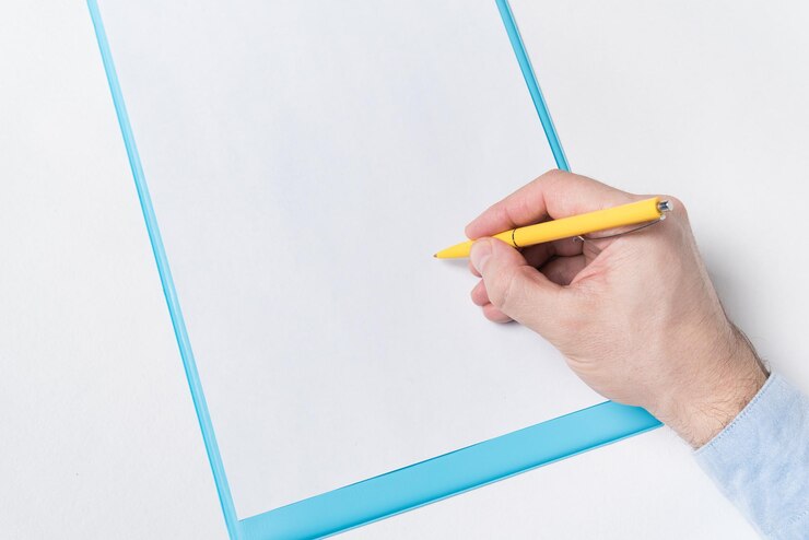 Foto mano masculina con bolígrafo en una hoja de papel en blanco el hombre pone la firma en el papel vista superior