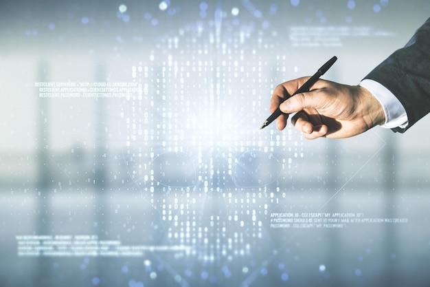 Mano masculina con bolígrafo que trabaja con holograma de cráneo de código creativo virtual abstracto sobre fondo de oficina borroso robo de datos personales y concepto de malware Multiexposición