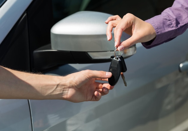 Foto mano masculina dando llaves de coche a mano femenina