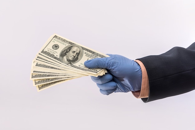 Mano masculina dar dólar para pagar en guantes protectores de seguridad aislado sobre fondo blanco. concepto médico covid 19 coronavirus