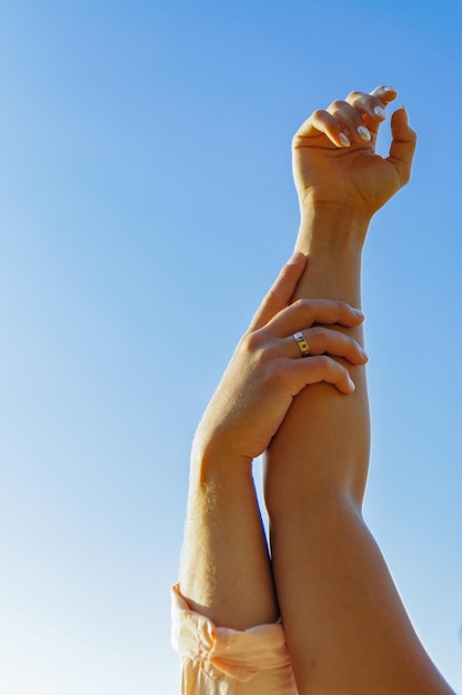 Mano masculina y femenina sobre un fondo de cielo azul