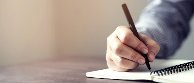 Foto mano masculina con lápiz escribiendo en el cuaderno