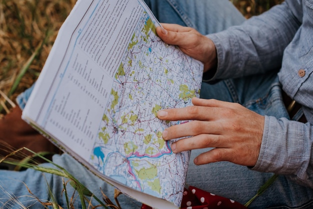 La mano masculina en el mapa de la carretera