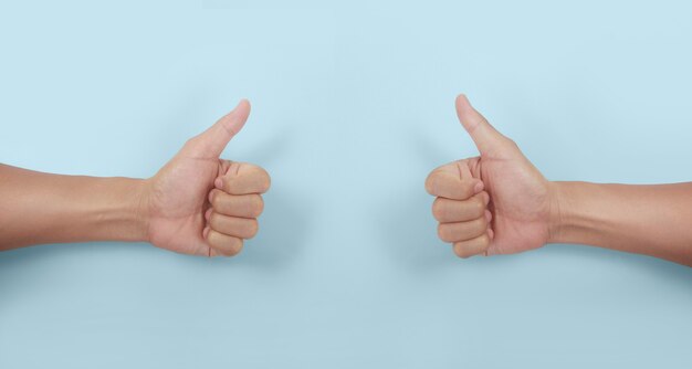Mano masculina mostrando los pulgares para arriba signo contra