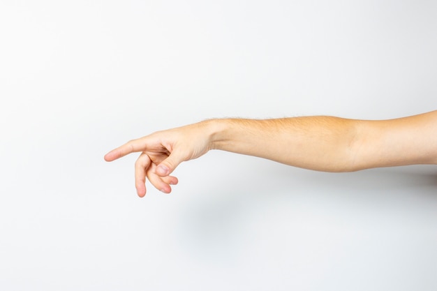 La mano masculina muestra un dedo. La mano del hombre apuntando a un objeto invisible en una luz