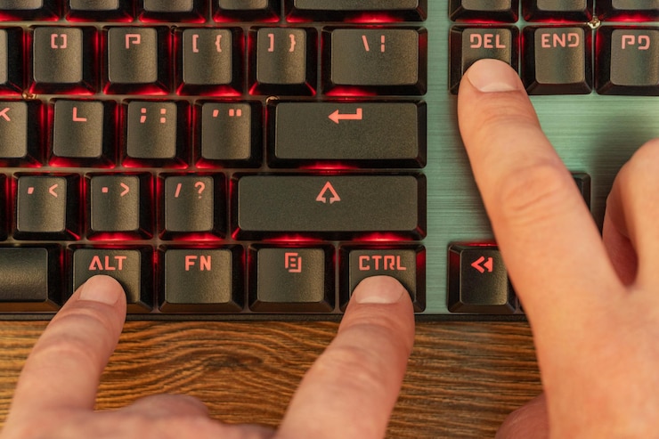 Foto la mano masculina presiona tres teclas simultáneamente en el teclado negro - control alt y eliminar