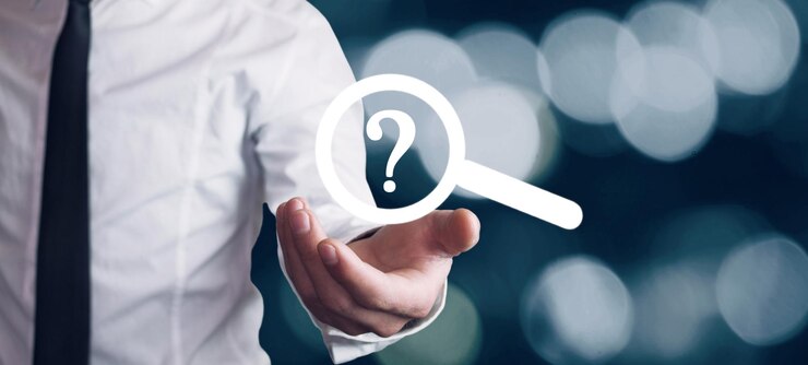 Foto mano masculina que muestra una lupa con un signo de interrogación