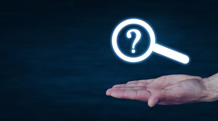 Foto mano masculina que muestra una lupa con un signo de interrogación