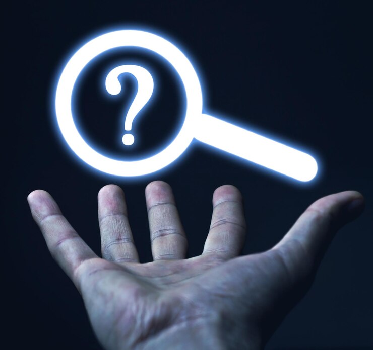 Foto mano masculina que muestra una lupa con un signo de interrogación