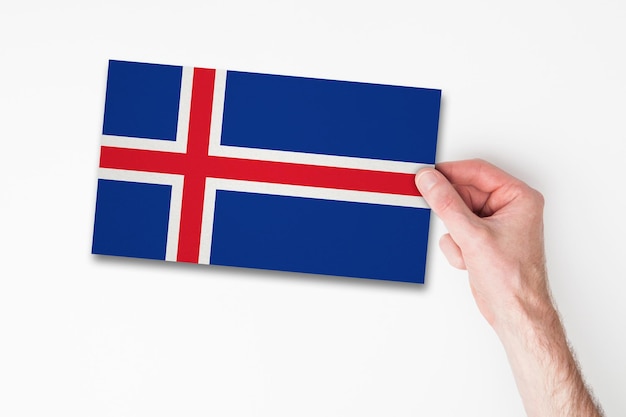 Mano masculina que sostiene la bandera de islandia