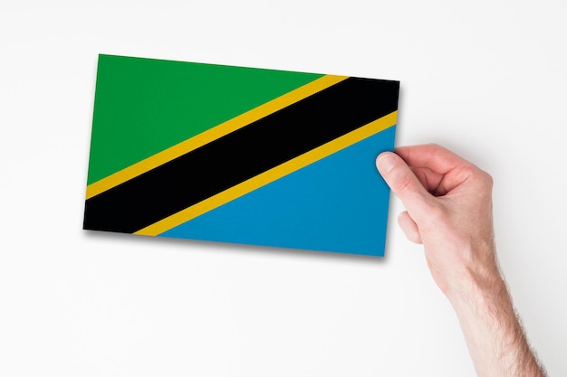 Mano masculina que sostiene la bandera de tanzania