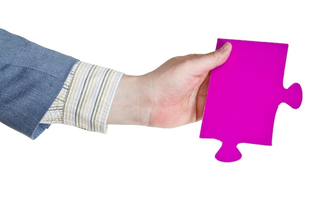 Foto mano masculina sosteniendo una gran pieza de rompecabezas de papel rosa