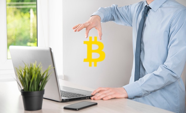 Mano masculina sosteniendo un icono de bitcoin sobre fondo azul. Bitcoin Cryptocurrency Digital Bit Coin BTC Moneda Tecnología Negocios Internet Concepto.