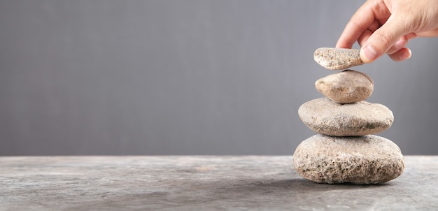 Mano masculina sosteniendo la piedra de equilibrio.