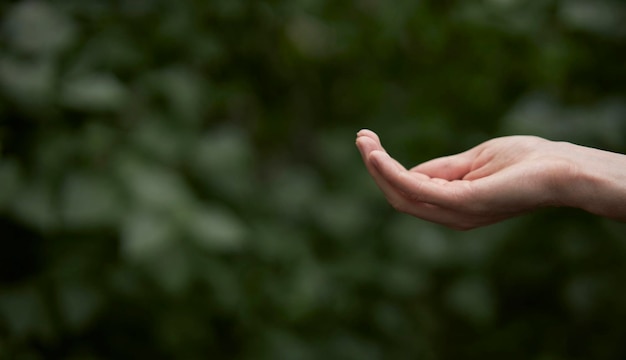 Mano masculina de tecnología con íconos del medio ambiente a través de un fondo verde