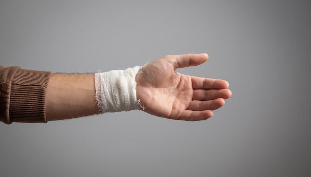 Mano masculina con venda El concepto de primeros auxilios