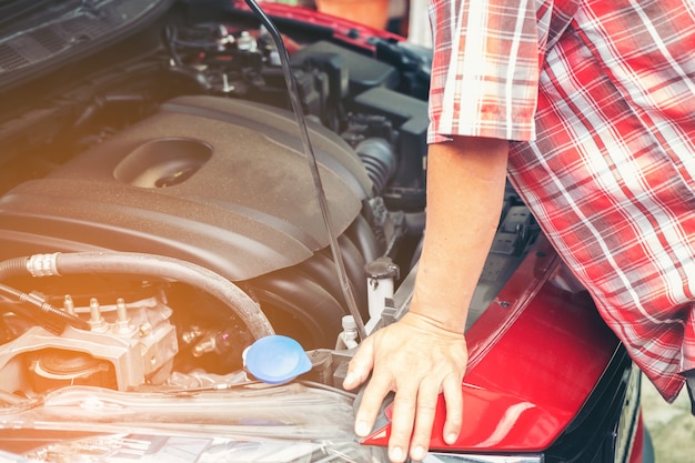 Foto mano del mecánico de automóviles con una llave. mecánico de reparación de automóviles que comprueba el motor de coche en servicio de coches.