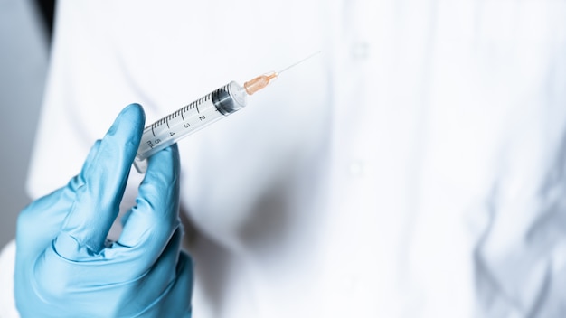 Mano de médico o enfermera con inyección de vacuna contra la gripe para la vacunación del bebé