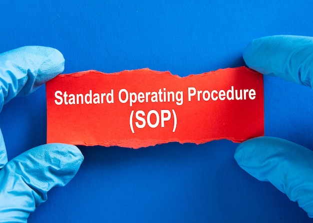 Mano del médico con la palabra Procedimiento operativo estándar SOP Concepto médico de coronavirus