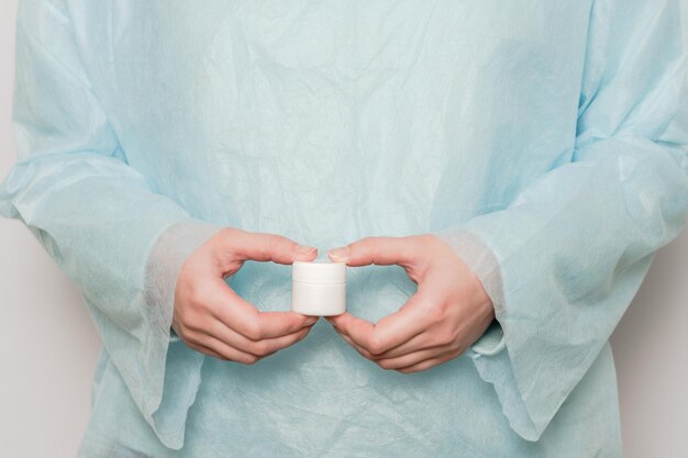 Mano del médico sosteniendo un frasco de tabletas de pastillas de ungüento Maqueta de botella de medicina