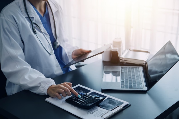 Mano del médico sosteniendo la pluma escribiendo la lista del historial del paciente en el portapapeles sobre medicamentos y tratamiento