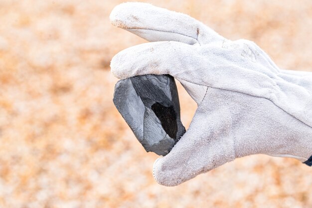 Foto mano de minero con piedra de hierro