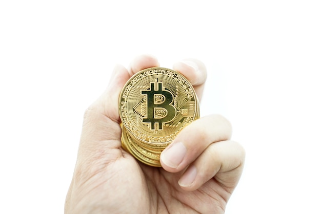 mano con la moneda de oro bitcoin en el fondo blanco.