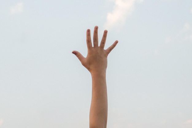 Mano mostrando el número cinco símbolo de gesto en el fondo azul brillante del cielo de verano naturaleza gesto número cinco número uno en lenguaje de señas quinto y contando cinco conceptos cinco dedo hacia arriba