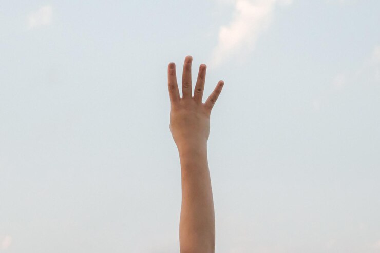 Foto mano mostrando el número cuatro símbolo de gesto en el fondo de la naturaleza del cielo azul brillante de verano gestando el número cuatro en lenguaje de señas cuarto y contando cuatro conceptos 4 dedo hacia arriba