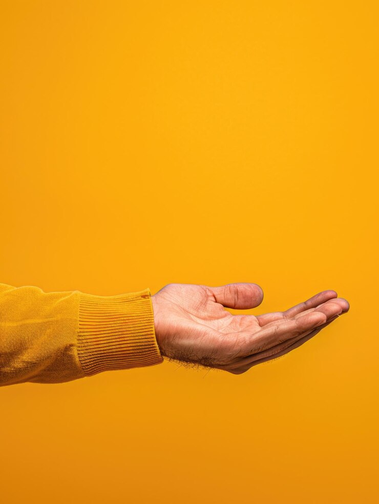 Foto una mano se muestra en una camisa amarilla con un fondo blanco