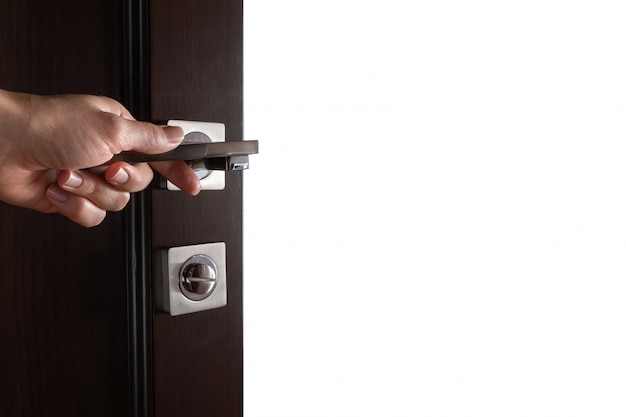 Foto la mano de la mujer abre la puerta de madera negra.