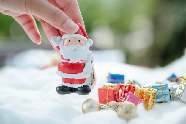 Foto mano de mujer arreglando coloridos personajes navideños y decoraciones.
