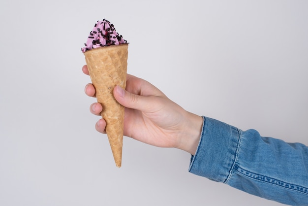 Mano de mujer en camisa de mezclilla con helado aislado