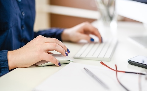 Mano de mujer con computadora en casa, oficina.