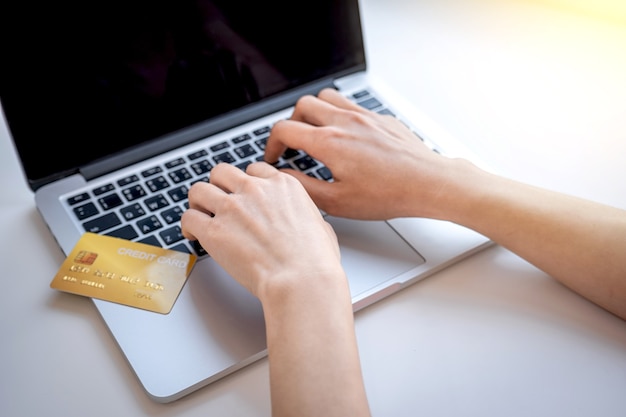 Mano de mujer consumidor usando laptop para compras en línea