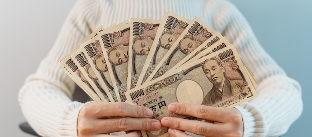 Mano de mujer contando billetes de yen japonés sobre el fondo de la mesa Dinero de mil yenes Japón efectivo Recesión fiscal Economía Inflación Inversión finanzas ahorros salarios y conceptos de pago