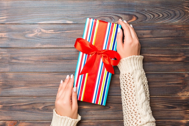 Foto mano de mujer dar caja de regalo de san valentín, vista superior