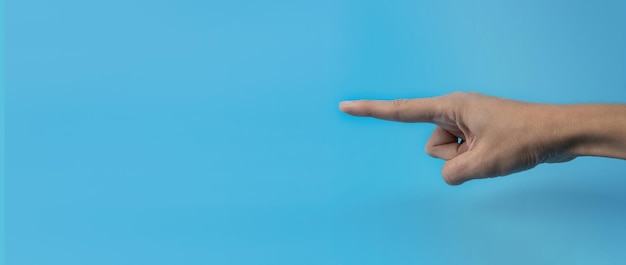 Foto una mano de mujer con un dedo índice sobre un fondo azul copia espacio banner