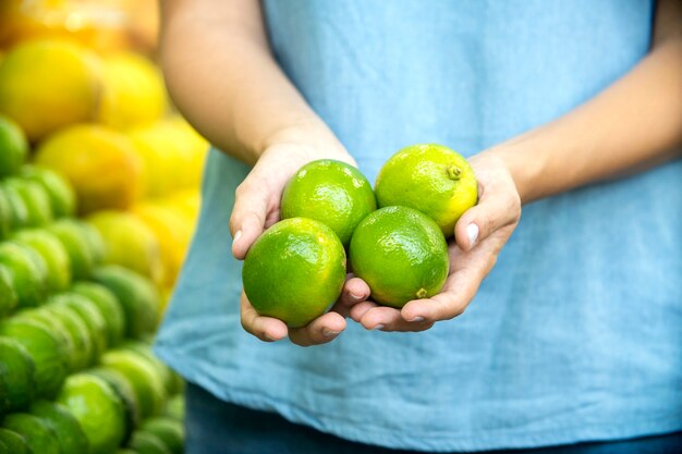 Mano de mujer eligiendo limones en el supermercado.