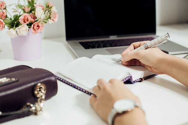 Mano de mujer escribiendo en el Bloc de notas vacío