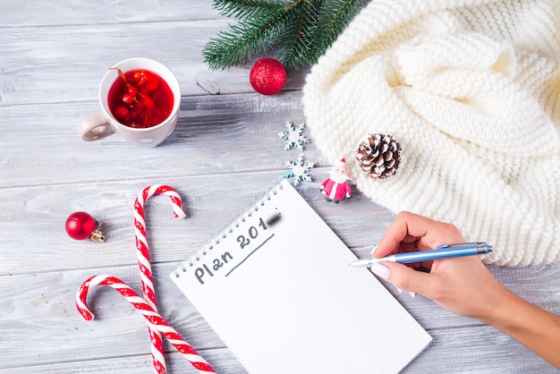 Mano de mujer escribiendo saludos de Navidad