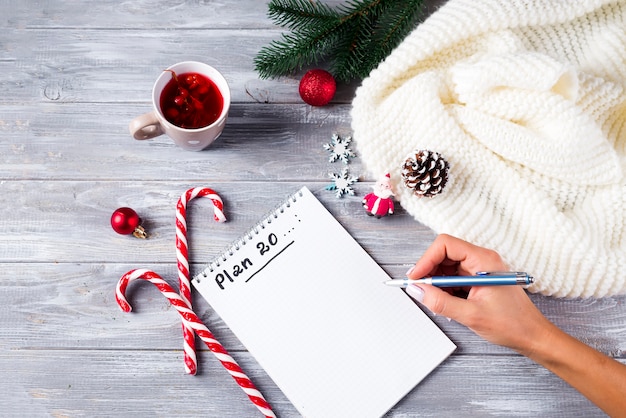 Mano de mujer escribiendo saludos de Navidad