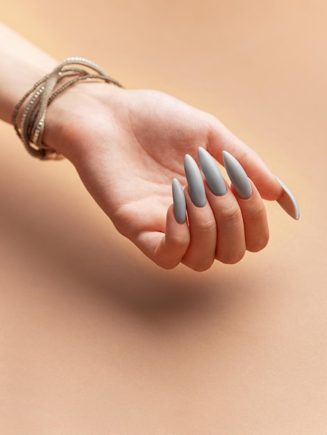 Foto la mano de la mujer con esmalte de uñas gris