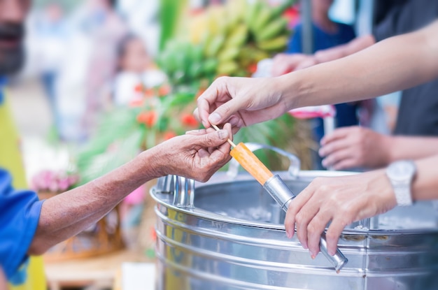 La mano de la mujer está dando helado al anciano