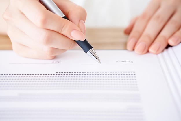 Mano de mujer firmando un documento