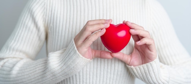 Mano de mujer con forma de corazón rojo amor donante día mundial del corazón día mundial de la salud y conceptos de seguros