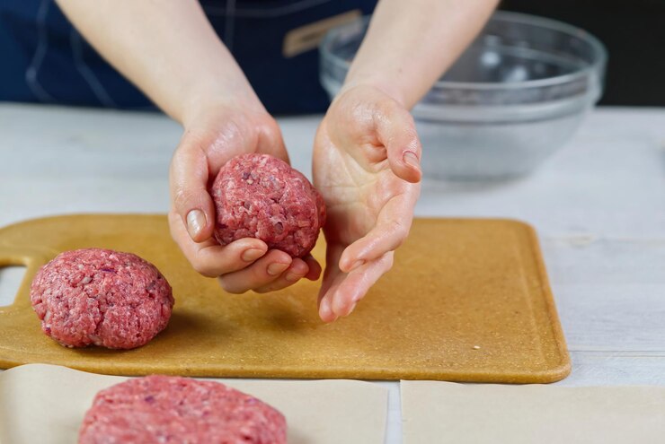 Mano de mujer formando una carne de res para una fiesta de hamburguesas Porciones de carne molida Hamburguesas caseras Hacer comida en casa de cerca